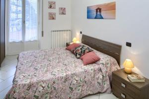 um quarto com uma cama com um edredão rosa em Fernanda 2 em Levanto