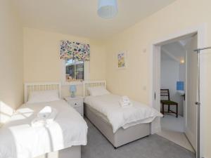 a bedroom with two beds and a window at Glenconner Garden Cottage in North Berwick