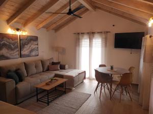 a living room with a couch and a table at Garitsa Apartments B in Agios Rokkos