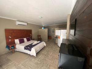 1 dormitorio con 1 cama y TV de pantalla plana en Hoon's Selfcatering, en Karasburg