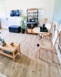 a living room with wooden floors and a table and chairs at Le Cotil Ribes in Grangues