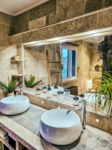 a bathroom with two sinks and a large mirror at Le Cotil Ribes in Grangues