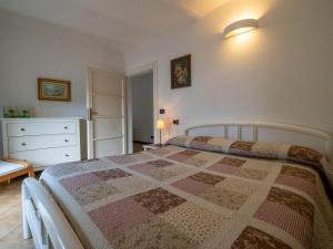 a bedroom with a bed with a quilt on it at Villa Albertina in Varenna