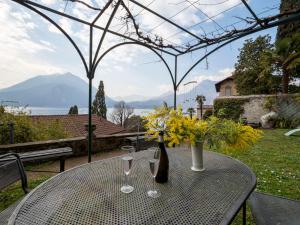 una mesa con dos copas de vino y flores en ella en Villa Albertina en Varenna