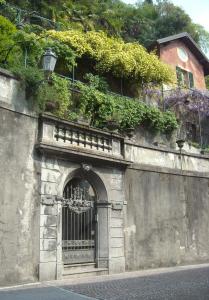 una pared de piedra con una puerta delante de un edificio en Villa Albertina en Varenna