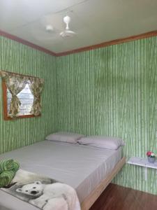 a bed in a room with green striped walls at Green Acres Village in Moalboal