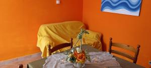 a table with a vase of flowers on it at LES PETITES MAISONS maison orange in Procida +8 photos