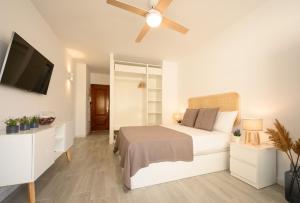 - une chambre blanche avec un lit et une télévision à écran plat dans l'établissement Ramon y Cajal by 10ToSea, à Fuengirola
