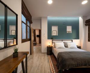 - une chambre avec un grand lit et un mur bleu dans l'établissement Santa Escolástica en pleno centro de Granada, à Grenade