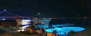 a building with a pool and a bridge at night at Flora Hotel in Gelibolu