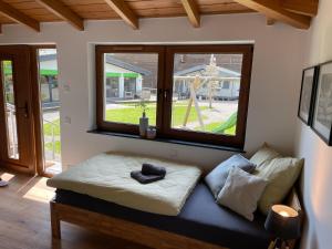 ein Sofa in einem Zimmer mit zwei Fenstern in der Unterkunft Rönkhausen Appartements in Finnentrop