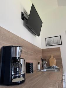 una encimera de cocina con cafetera y TV en Rönkhausen Appartements, en Finnentrop