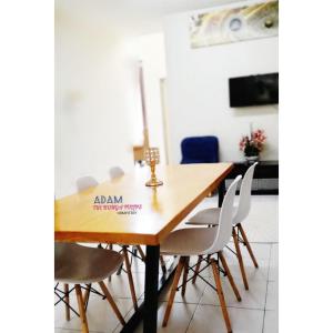 a dining room table with chairs and aania sign on it at AdamPoolHomestay in Alor Setar