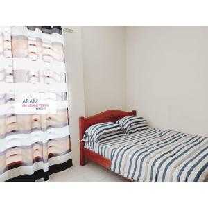 a small bedroom with a bed and a window at AdamPoolHomestay in Alor Setar