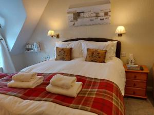 a bedroom with a bed with two towels on it at The Norwood in Torquay