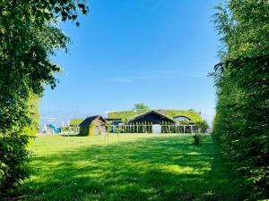a green yard with a building with a grass roof at Karczma Viking in Stara Kiszewa