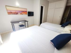 a hotel room with two beds and a table at Hotel Don Cándido in Puerto de la Cruz
