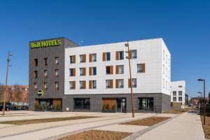 um edifício branco com uma placa em cima em B&B HOTEL Bois d'Arcy Saint Quentin en Yvelines em Bois-dʼArcy