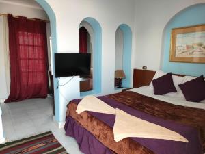 シャルム・エル・シェイクにあるHalomy Sharm Resortのベッドルーム(ベッド1台、薄型テレビ付)
