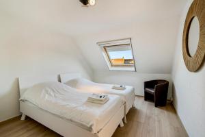 a small bedroom with a bed and a chair at Holidayhouse Kongé, a place that you call home! in Bruges