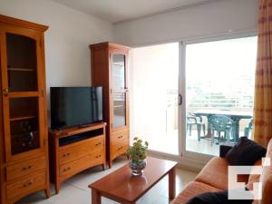 sala de estar con TV en un centro de entretenimiento de madera en Apartamento Apolo XVII 22 - Grupo Turis, en Calpe