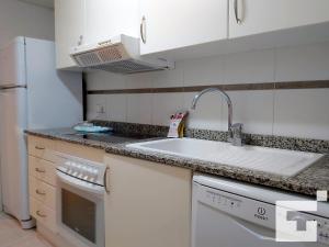cocina blanca con fregadero y lavavajillas en Apartamento Apolo XVII 22 - Grupo Turis en Calpe