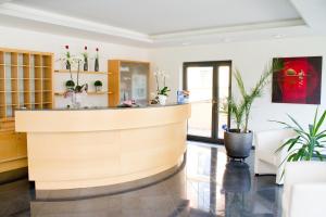 a lobby with a reception counter and potted plants at Schweigerhof in Ismaning