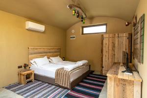 1 dormitorio con 1 cama y TV en Хотел Глемпинг Алианс en Plovdiv