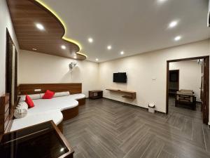 a hotel room with two beds and a tv at Singaras Coffee Country in Masinagudi