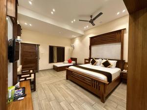 a hotel room with a bed and a television at Singaras Coffee Country in Masinagudi