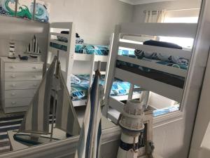 a room with a bunk bed with a mirror at The Whale Tale Villa in St Helena Bay