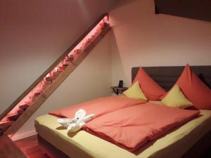 a bedroom with a bed with red and yellow pillows at Ferienwohnung Lichtspiel - a58017 in Peiting