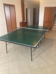 a ping pong table with two tennis rackets on it at Bazilika Vendégház in Tarcal