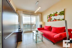 un soggiorno con divano rosso e finestra di Apartamento Apolo XVIII 59 - Grupo Turis a Calpe