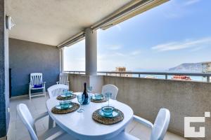 une salle à manger avec une table blanche et des chaises blanches dans l'établissement Apartamento Apolo XVIII 59 - Grupo Turis, à Calp