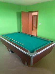 a pool table in a room with green walls at Bazilika Vendégház in Tarcal