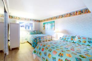 a bedroom with two beds and a wall with a bedspread with fish at Sandpiper Dunes 109 in Ocean City +14 photos