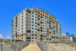 a tall building on the beach next to a fence at Sandpiper Dunes 109 in Ocean City