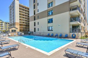 a swimming pool with chairs and a building at Sandpiper Dunes 109 in Ocean City