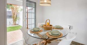 a dining room with a glass table and chairs at Sunset Bungalow Ocean View Palm Mar in Palm-Mar