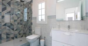 Un baño con inodoro, lavabo y espejo. en Sunset Bungalow Ocean View Palm Mar, en Palm-mar 22 fotos más