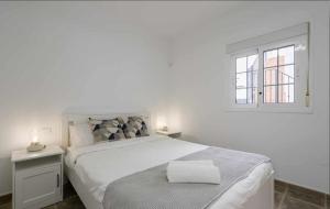 Un dormitorio blanco con una cama grande y una ventana. en Sunset Bungalow Ocean View Palm Mar, en Palm-mar