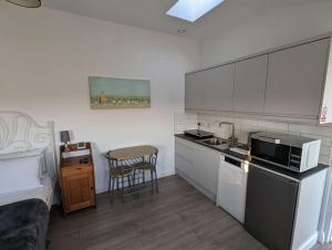 a kitchen with a sink and a stove top oven at The Studio @ Cleeve Hill in Bath
