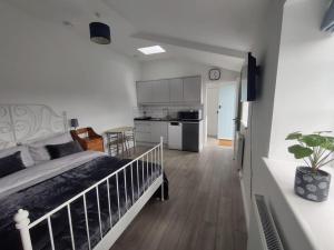 a bedroom with a large bed and a kitchen at The Studio @ Cleeve Hill in Bath