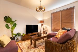uma sala de estar com dois sofás e uma televisão em Y's沖縄リゾートベースNo.2 em Onna