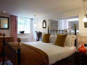 una camera da letto con un grande letto con cuscini gialli di Monachyle Mhor Hotel a Lochearnhead
