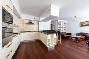 cocina con armarios blancos y sala de estar. en Bukowińska 12 Prywatne mieszkanie 80m2 z dwiema sypialniami i balkonem 2x bezpłatne miejsca parkingowe, en Varsovia