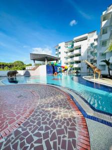 a swimming pool with giraffes and a building at Homelite Resort in Miri