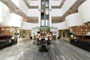 um átrio com um lustre e uma mesa com flores em Metropolitan Hotels Ankara em Ancara