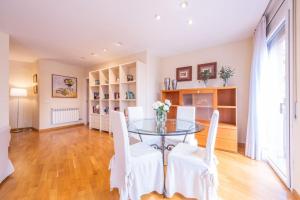 une salle à manger avec une table en verre et des chaises blanches dans l'établissement Figueres, à Figueres